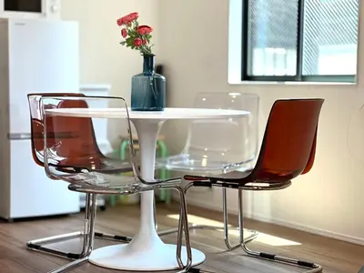 two chairs and a white table with a vase with flowers at Shibuya House-SY0108 in Tokyo