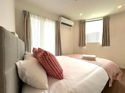 a bedroom with a bed with pillows and a window at Shibuya House-SY0108 in Tokyo
