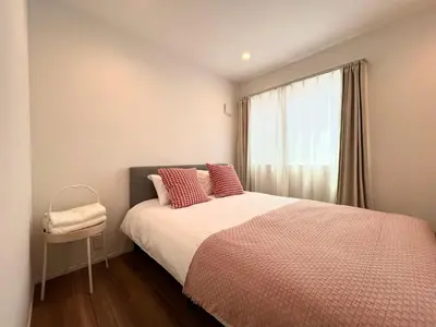 a bedroom with a bed with red pillows and a window at Shibuya House-SY0108 in Tokyo