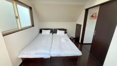 a bedroom with a bed with white sheets and a window at JING HOUSE Shintakasago - Vacation STAY 17117 in Tokyo
