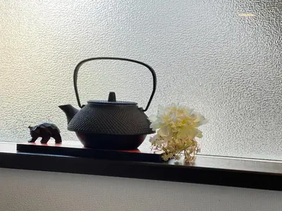 a black tea pot and flowers on a shelf at JING HOUSE Shintakasago - Vacation STAY 17117 in Tokyo