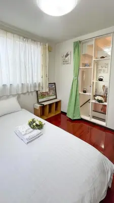 a bedroom with a white bed with flowers on it at JING HOUSE Shintakasago - Vacation STAY 17117 in Tokyo
