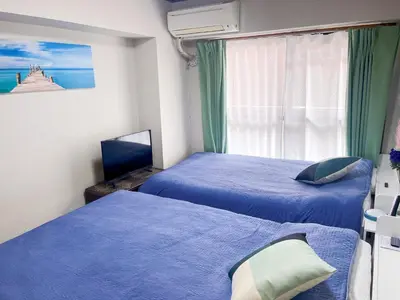 a bedroom with two beds and a window at JR\u5c71\u624b\u7dda\u99d2\u8fbc\u8f66\u7ad9\u6b65\u884c3\u5206\u949f \u76f4\u8fbe\u65b0\u5bbf \u6da9\u8c37 \u4e0a\u91ce \u6c60\u888b\u7b49 \u514d\u8d39wifi in Tokyo