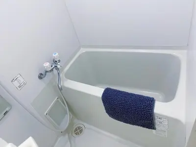 a white bath tub with a blue towel around it at JR\u5c71\u624b\u7dda\u99d2\u8fbc\u8f66\u7ad9\u6b65\u884c3\u5206\u949f \u76f4\u8fbe\u65b0\u5bbf \u6da9\u8c37 \u4e0a\u91ce \u6c60\u888b\u7b49 \u514d\u8d39wifi in Tokyo