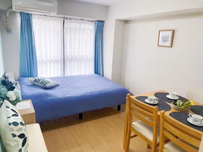a small bedroom with a blue bed and a table at JR\u5c71\u624b\u7dda\u99d2\u8fbc\u8f66\u7ad9\u6b65\u884c3\u5206\u949f \u76f4\u8fbe\u65b0\u5bbf \u6da9\u8c37 \u4e0a\u91ce \u6c60\u888b\u7b49 \u514d\u8d39wifi in Tokyo