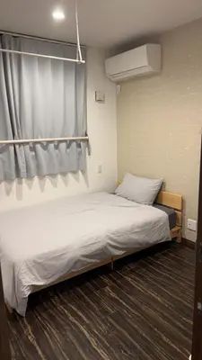 a bedroom with a large bed with a curtain at \u6c11\u6ccaTOKYO one \u30b7\u30a7\u30a2\u30cf\u30a6\u30b9 in Tokyo