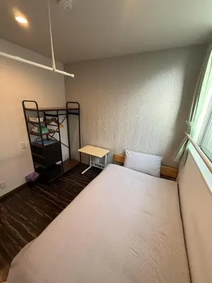 a small room with a bed and a shelf at \u6c11\u6ccaTOKYO one \u30b7\u30a7\u30a2\u30cf\u30a6\u30b9 in Tokyo