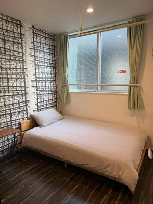 a bed in a room with a window at \u6c11\u6ccaTOKYO one \u30b7\u30a7\u30a2\u30cf\u30a6\u30b9 in Tokyo