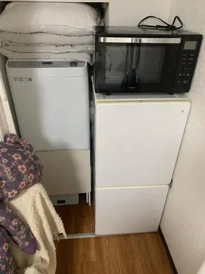a microwave sitting on top of a refrigerator at Lions B in Tokyo