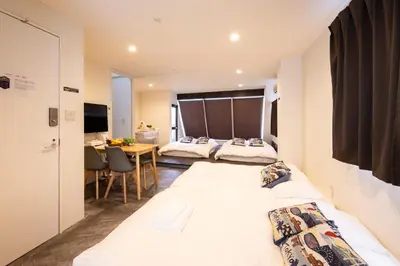 a hotel room with two beds and a table at -花雷 はならい in 浅草&雷門- 浅草駅から徒歩5分 ベビー用品付き ファミリーも歓迎 大人8名もOK!! in Tokyo
