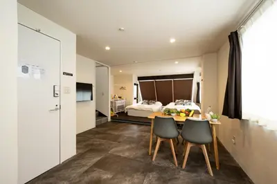 a room with a table and two chairs and a bed at -花雷 はならい in 浅草&雷門- 浅草駅から徒歩5分 ベビー用品付き ファミリーも歓迎 大人8名もOK!! in Tokyo