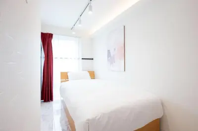 a bedroom with a white bed and a red curtain at Recorrido Yoyogi in Tokyo