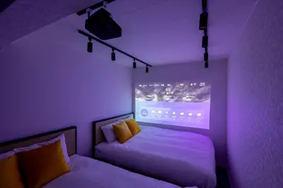 a purple room with two beds and a projector at Recorrido Yoyogi in Tokyo