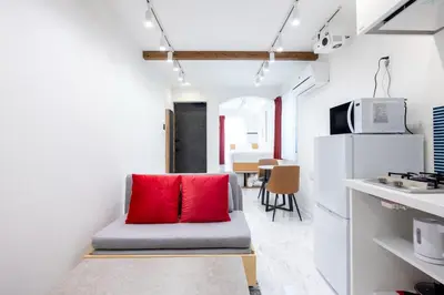 a living room with a red pillow on a couch at Recorrido Yoyogi in Tokyo