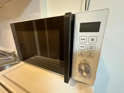 a microwave oven sitting on top of a kitchen counter at SOLASIA residence \u5317\u4e0a\u91ce501 in Tokyo