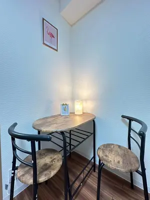 a table and two chairs in front of a wall at SOLASIA residence \u5317\u4e0a\u91ce501 in Tokyo