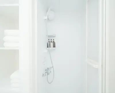 a shower in a bathroom with white walls and a shower at \u6771\u4eac\u30ea\u30ea\u30a2\u30eb\u30db\u30c6\u30eb 301 in Tokyo