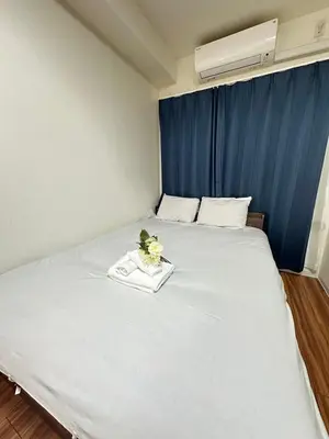 a large white bed with a tray of flowers on it at SOLASIA residence \u5317\u4e0a\u91ce601 in Tokyo
