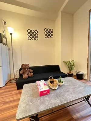 a teddy bear sitting on a couch in a living room at SOLASIA residence \u5317\u4e0a\u91ce601 in Tokyo