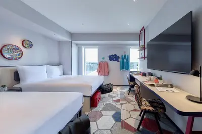 a hotel room with two beds and a desk at lyf Shibuya Tokyo in Tokyo