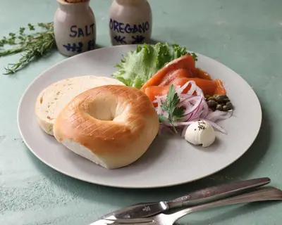 a plate with a bagel and vegetables on a table at lyf Shibuya Tokyo in Tokyo