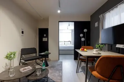 a living room with a table and chairs and a television at Ruygo\u65b0\u5bbf\u897f\u843d\u5408 in Tokyo