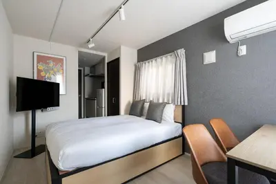 a bedroom with a bed and a table and a desk at Ruygo\u65b0\u5bbf\u897f\u843d\u5408 in Tokyo