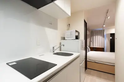 a kitchen with a sink and a refrigerator and a bed at Ruygo\u65b0\u5bbf\u897f\u843d\u5408 in Tokyo