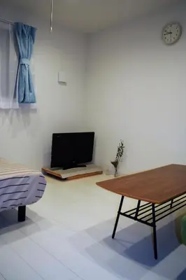 a living room with a table and a couch at The FLAT 103 in Tokyo