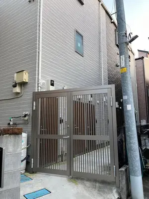 a gate in front of a house with a building at The FLAT 103 in Tokyo