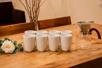 a group of white cups on a wooden table with a blender at Villa Shibuya East , \u6e0b\u8c37\u6771\u30f4\u30a3\u30e9 in Tokyo
