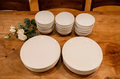 a group of white plates on a wooden table at Villa Shibuya East , \u6e0b\u8c37\u6771\u30f4\u30a3\u30e9 in Tokyo