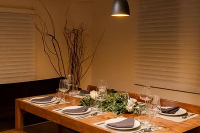 a wooden table with glasses and flowers on it at Villa Shibuya East , \u6e0b\u8c37\u6771\u30f4\u30a3\u30e9 in Tokyo