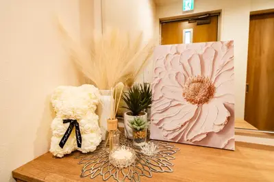 a table with flowers and a painting on it at 64, Shiomi , Second floor of the apartment, \u6f6e\u898b2F in Tokyo