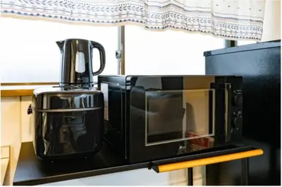 a black microwave oven sitting on a kitchen counter at 64, Shiomi , Second floor of the apartment, \u6f6e\u898b2F in Tokyo