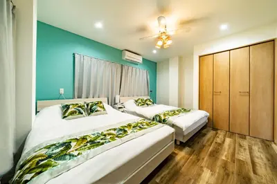 two beds in a bedroom with blue walls and wooden floors at 63, Shiomi, First floor of the apartment, \u6f6e\u898b1F in Tokyo