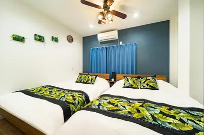 a bedroom with two beds and a ceiling fan at 63, Shiomi, First floor of the apartment, \u6f6e\u898b1F in Tokyo