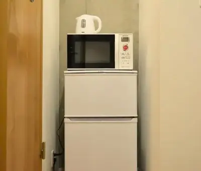 a microwave sitting on top of a refrigerator at \u56fd\u7acb\u7af6\u6280\u5834\u305d\u3070\u65b0\u5bbf\u5fa1\u82d1\u76ee\u306e\u524d Luxe designer Residence near National Stadium built four years ago ,Max4ppl,3adaults in Tokyo