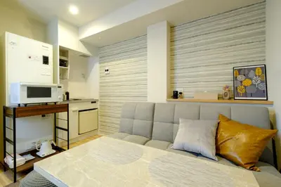 a living room with a bed and a kitchen at Asakusa Landing - \u96f7\u9580\u3084\u6d45\u8349\u5bfa\u307e\u3067\u5f92\u6b69\u570f\u5185 - \u7121\u6599Wi-Fi\u3084\u30d7\u30ed\u30b8\u30a7\u30af\u30bf\u30fc\u5b8c\u5099 in Tokyo