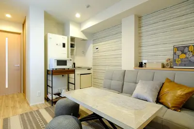 a living room with a couch and a table at Asakusa Landing - \u96f7\u9580\u3084\u6d45\u8349\u5bfa\u307e\u3067\u5f92\u6b69\u570f\u5185 - \u7121\u6599Wi-Fi\u3084\u30d7\u30ed\u30b8\u30a7\u30af\u30bf\u30fc\u5b8c\u5099 in Tokyo