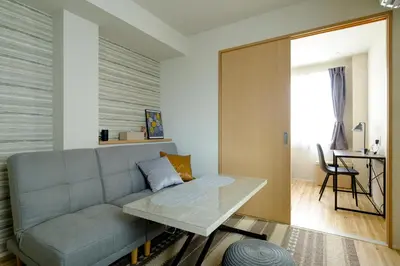 a living room with a couch and a table at Asakusa Landing - \u96f7\u9580\u3084\u6d45\u8349\u5bfa\u307e\u3067\u5f92\u6b69\u570f\u5185 - \u7121\u6599Wi-Fi\u3084\u30d7\u30ed\u30b8\u30a7\u30af\u30bf\u30fc\u5b8c\u5099 in Tokyo