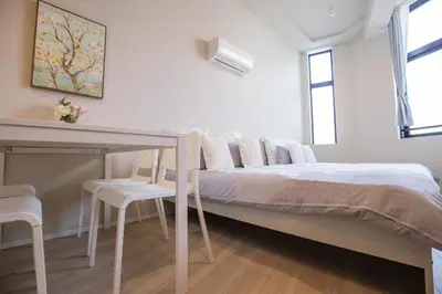 a white bedroom with a bed and a table at The best choice for accommodation in Yoyogi SoYk in Tokyo