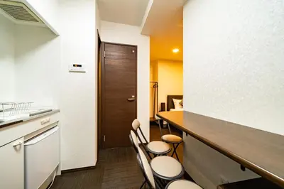 a kitchen with a counter and chairs in a room at 79, Umejima, Entire house for rent, \u6885\u5cf6 in Tokyo