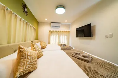a bedroom with a large bed and a flat screen tv at 79, Umejima, Entire house for rent, \u6885\u5cf6 in Tokyo