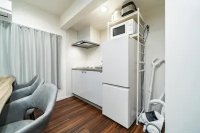 a small kitchen with two chairs and a refrigerator at 93, Yotsugi Seven, Entire house for rent, \u56db\u3064\u6728\u30bb\u30d6\u30f3 in Tokyo