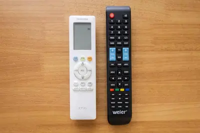 two remote controls sitting on top of a table at \u7be0\u30ac\u30fc\u30c7\u30f3\u30ec\u30b8\u30c7\u30f3\u30b9 in Tokyo