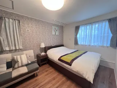 a bedroom with a bed and a couch at new open shinjuku house SJ0430 in Tokyo
