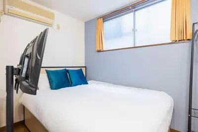 a bedroom with a bed with a large window at \u9326\u7cf8\u753a\u30b9\u30ab\u30a4\u30a8\u30a4\u30c8 in Tokyo