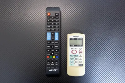 a remote control and a cell phone sitting next to each other at \u9326\u7cf8\u753a\u30b9\u30ab\u30a4\u30a8\u30a4\u30c8 in Tokyo