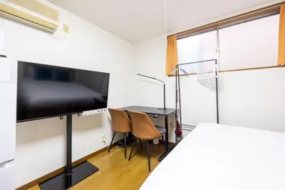 a bedroom with a bed and a desk and a tv at \u9326\u7cf8\u753a\u30b9\u30ab\u30a4\u30a8\u30a4\u30c8 in Tokyo